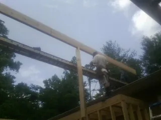 Carpenter setting a ridge beam over a new addition frame — Ice Dam Removal by Roofing Brothers in Miltona