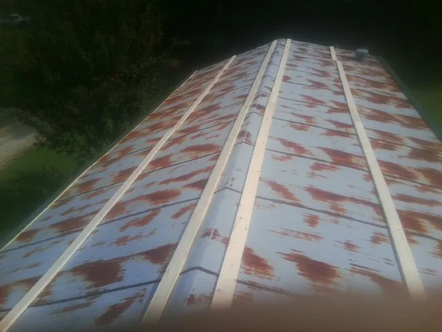 Rusted metal roof panels with new wood purlins before replacement — Storm Damage Roof Repair in Miltona by Roofing Brothers